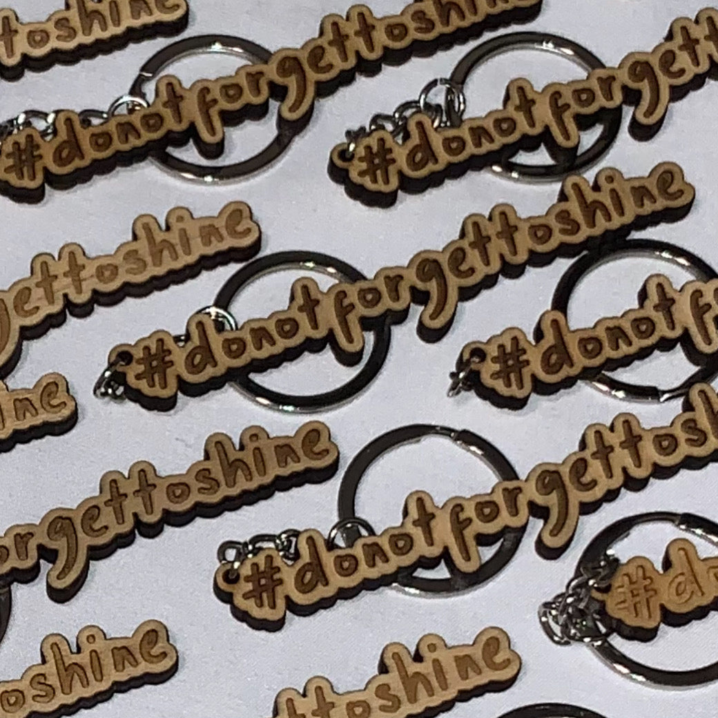 Collection of wood keychain '#dontforgettoshine' keychains on a white background