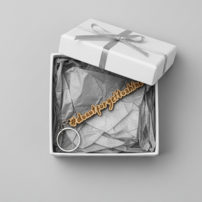 Wood keychain with '#dontforgettoshine' text in a gift box on a gray background