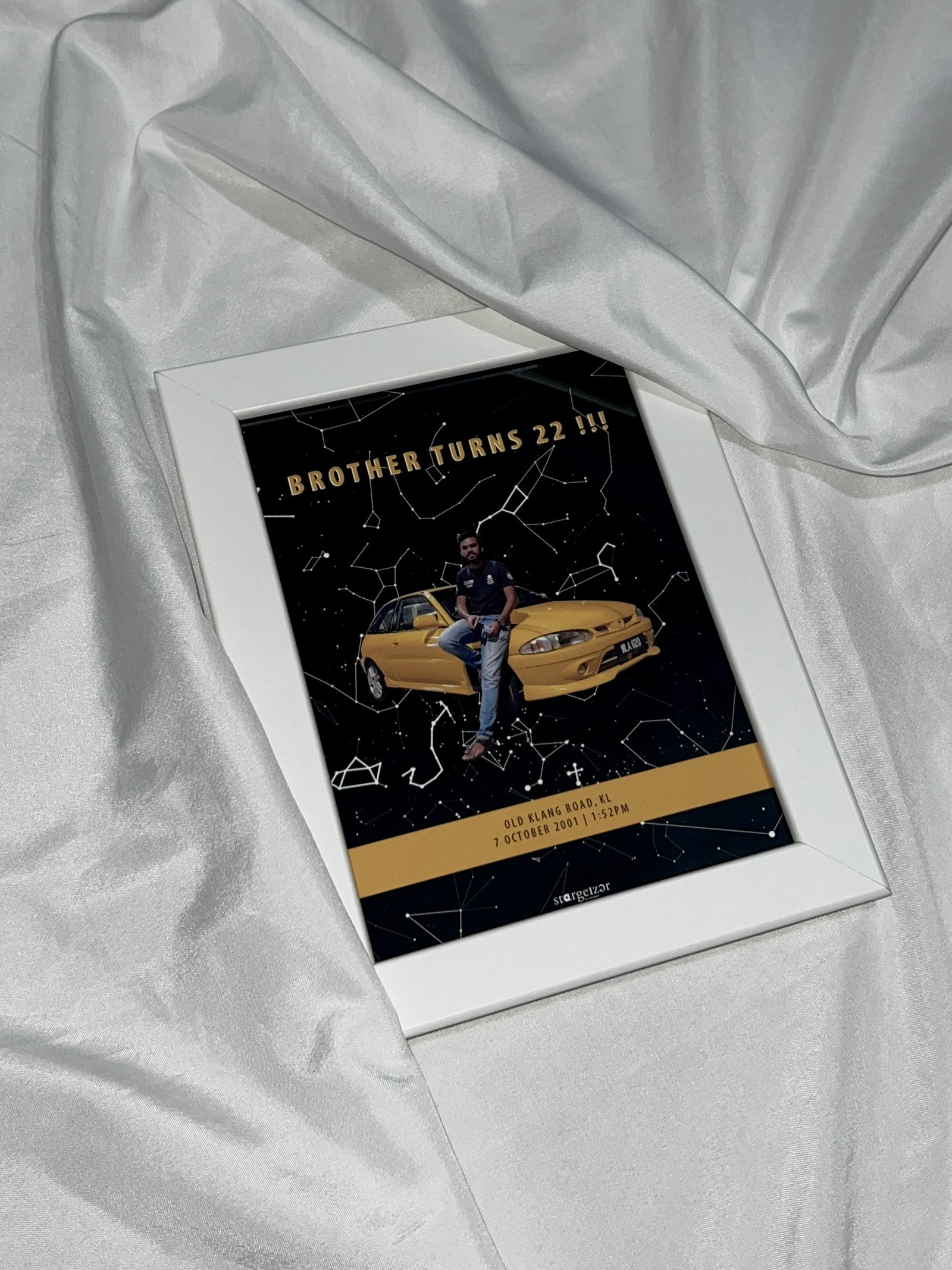 Framed custom star map with a young man and yellow car illustration, birthday dedication text, styled on silky fabric