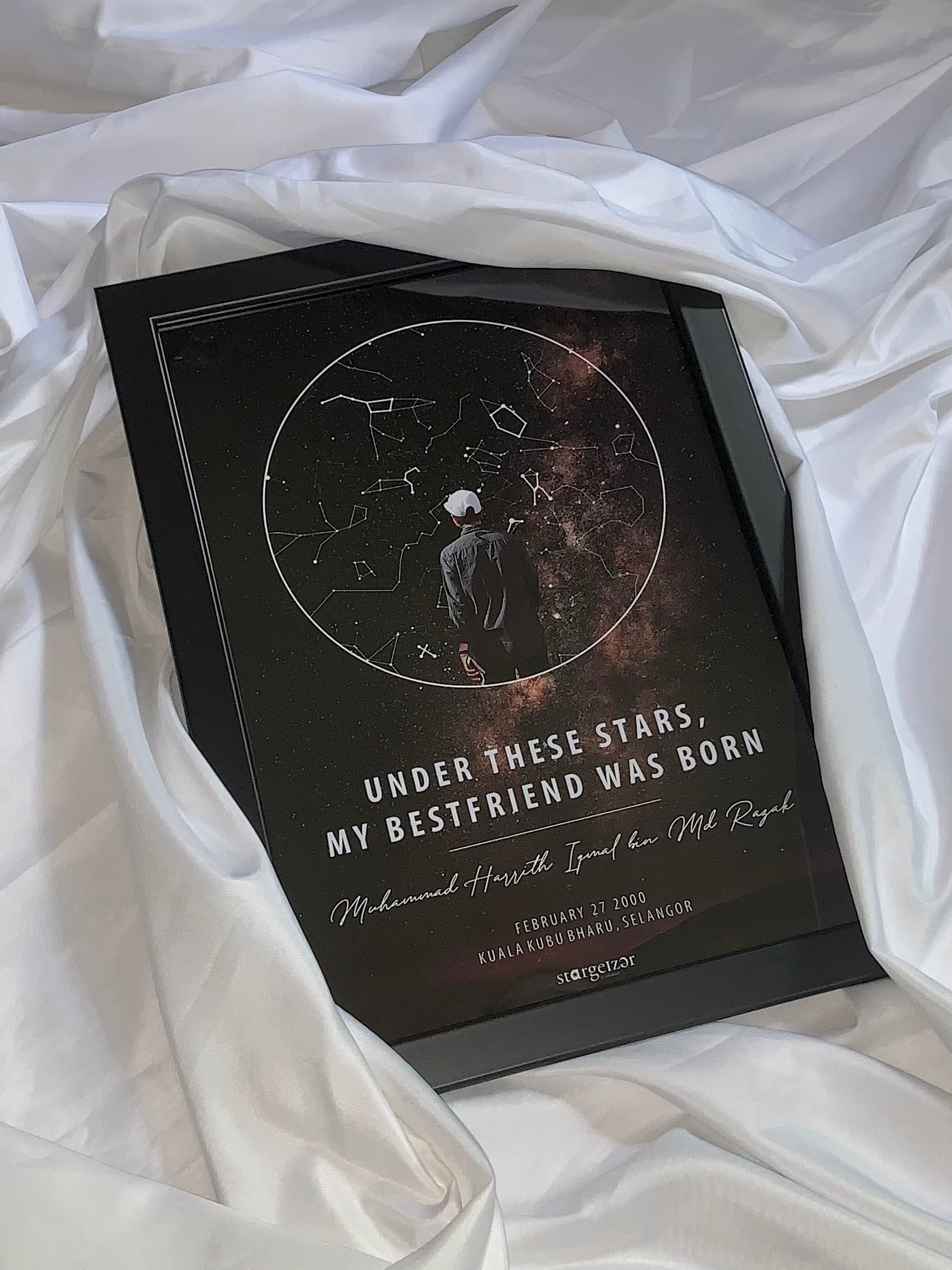 Framed custom star map with a silhouette of a person under cosmic sky, dedication text for best friend, styled on silky fabric.