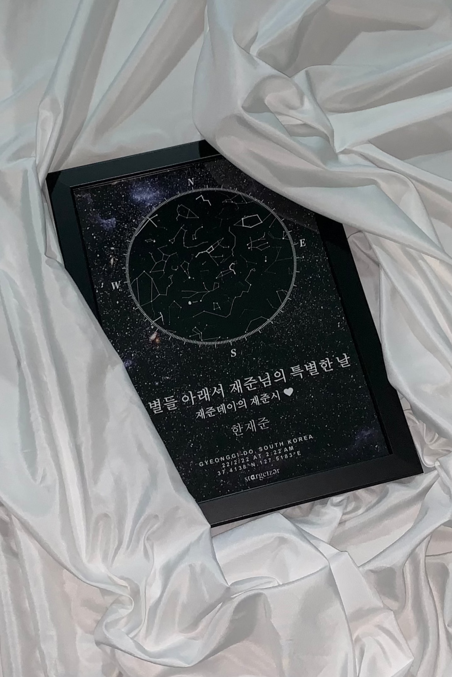 Framed custom star map with constellations and Korean dedication text, styled on silky white fabric.