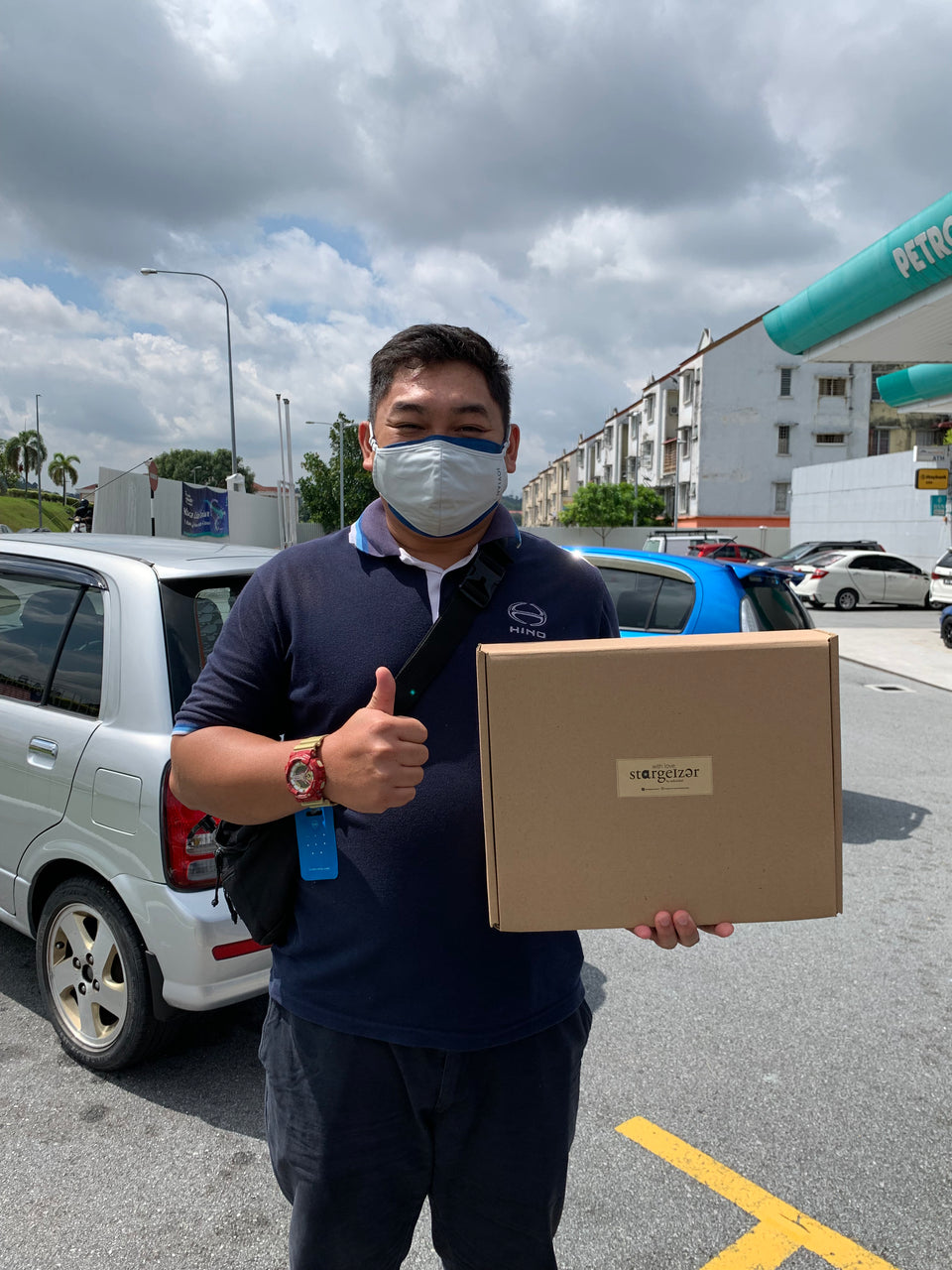Happy customer holding a Stargeizer gift box and giving a thumbs up after pickup.