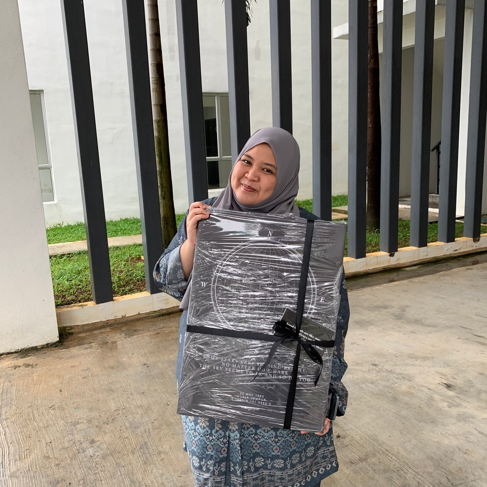 Woman holding an A2 size Stargeizer star map canvas gift outdoors.